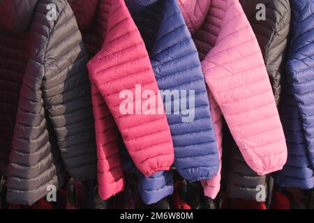 Winter jackets on outdoor clothing rack Stock Photo