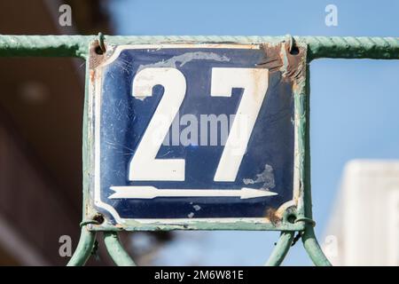 Weathered grunge square metal enameled plate of number of street address with number 27 Stock Photo