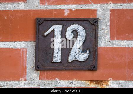 Old retro weathered cast iron plate with number 12 closeup Stock Photo