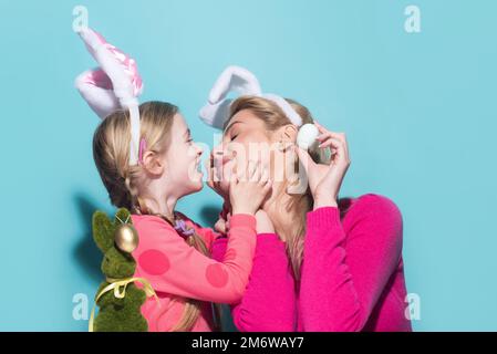 Family easter. Mom with daughter are preparing for Easter kissing. Mother and child wearing bunny ears. Easter banner, poster flyer header for website Stock Photo