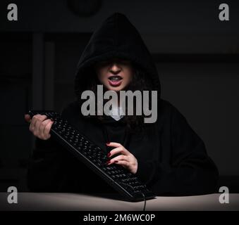 Female hacker hacking security firewall late in office Stock Photo