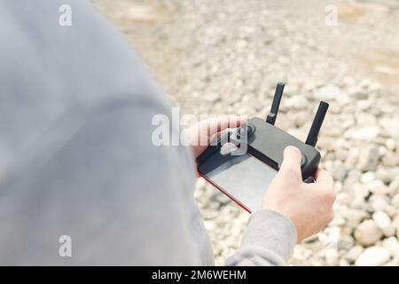 Male hands holding dron remote controller doing some setings Stock Photo