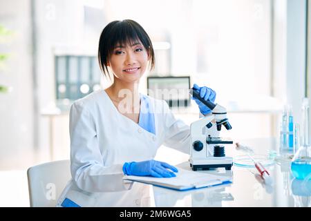 Smiling asian female scientist posing in modern medical research laboratory Stock Photo