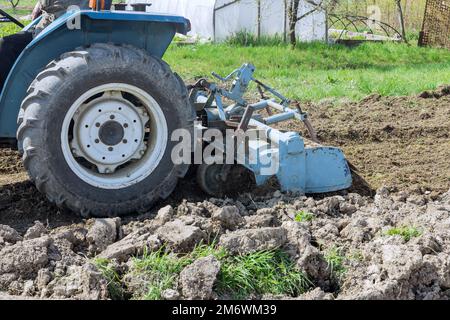 Using a tractor milling machine loosens and grinds soil before planting. Stock Photo