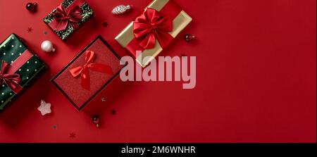 Christmas gift boxes with ribbon bows on red background. Christmas sale concept. Stock Photo