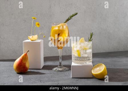 Summer sparkling cocktails on the white podiums. Hard seltzer cocktails with lemon and pear. Stock Photo