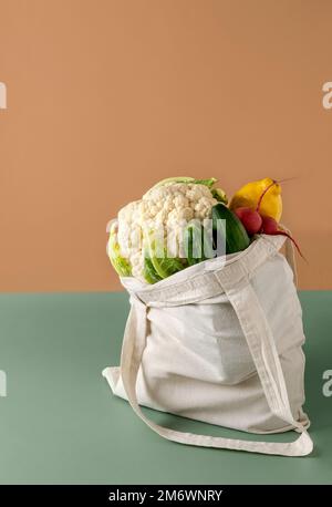 Eco bag with fresh vegetables on table in kitchen. Fresh vegetables and fruits in eco cotton bag on table. Zero waste concept Stock Photo