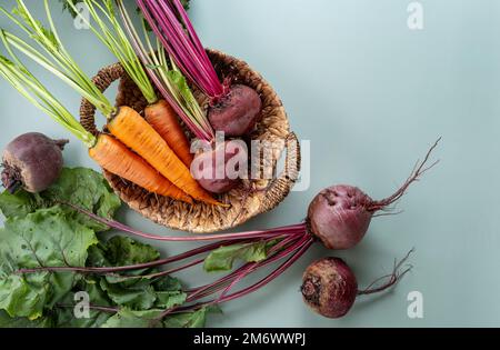 Freshly bunch harvest. Fresh farm vegetables in wicker basket. Healthy organic food, raw carrot and beetroot Stock Photo