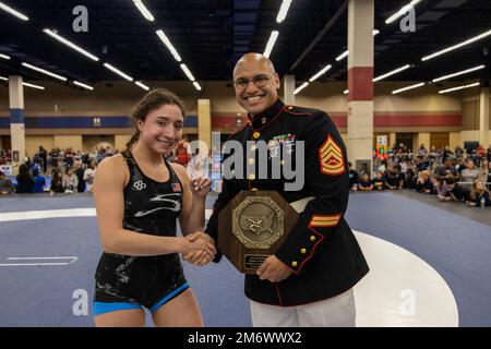 U.S. Marine Corps Gunnery Sgt. Justin. M. Boling, marketing and communications chief, presents an award to a winner of the 2022 during the USAW Women's National  at Fort Worth, Texas on May 07, 2022.. The Marine Corps began partnering with USAW in 2017 to share career opportunities, leadership and celebrate the spirit of competition while offering opportunities to athletes and coaches involved with the sport of wrestling. By partnering specifically with USAW, the Marine Corps reaches a broad cross-section of high school and collegiate-aged wrestlers as well as an ever-growing influencer networ Stock Photo
