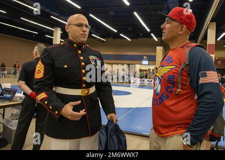 U.S. Marine Corps Gunnery Sgt. Justin. M. Boling, marketing and communications chief, speaks with a Marine veteran Coach  during the USAW Women's National  at Fort Worth, Texas on May 07, 2022.   The Marine Corps began partnering with USAW in 2017 to share career opportunities, leadership and celebrate the spirit of competition while offering opportunities to athletes and coaches involved with the sport of wrestling. By partnering specifically with USAW, the Marine Corps reaches a broad cross-section of high school and collegiate-aged wrestlers as well as an ever-growing influencer network of Stock Photo