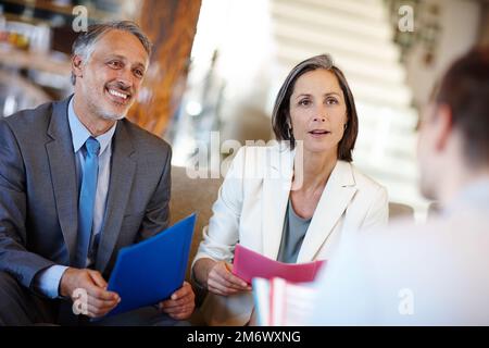 Theyve got a common vision. A cropped shot of three businesspeople sitting down to have a meeting. Stock Photo