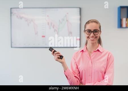 On Stage, Successful Female Speaker Presents Technological Product, Uses Remote Control for Presentation, Showing Infographics, Stock Photo