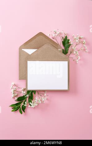 Blank greeting cards and envelopes with gypsophila on pink background. Blank paper sheet cards with mockup copy space. Minimal w Stock Photo