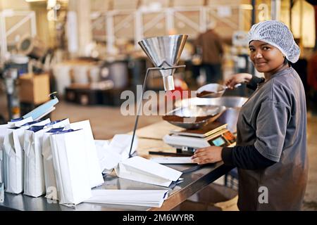 This coffee is best youll ever buy. Portrait of a woman working in a packing and distribution warehouse. Stock Photo