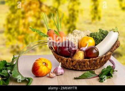 Freshly bunch harvest. Fresh farm vegetables in wicker basket. Healthy organic food, raw carrot, beetroot, potatoes and tomatoes Stock Photo