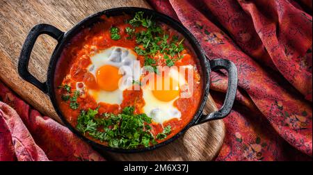 Shakshouka dish in a cast iron pan. Stock Photo