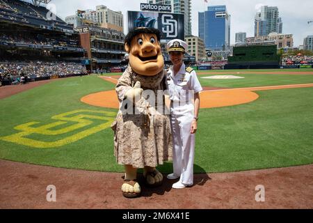 SAN DIEGO (May 8, 2022) – Capt. Katie Ellis, commanding officer of amphibious assault ship USS Boxer (LHD 4), poses for a photo with the San Diego Padre’s mascot the swinging friar on the field at Petco Park, May 8. The swinging friar has been the mascot of the San Diego Padres as early as 1958. Stock Photo