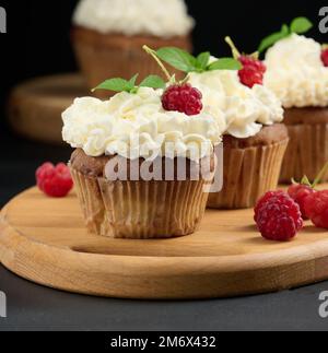 Baked cupcakes with white cream on the table, delicious dessert Stock Photo