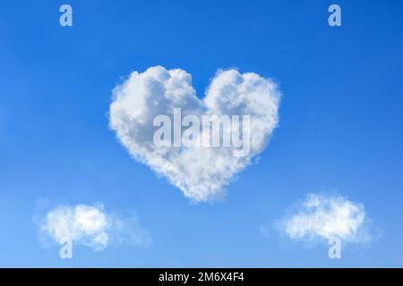 Heart shaped white clouds on bright blue sky during daytime, Valentines day concept Stock Photo