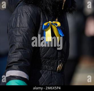 Yellow-blue ribbon on a black jacket, symbol of the Ukrainian flag Stock Photo