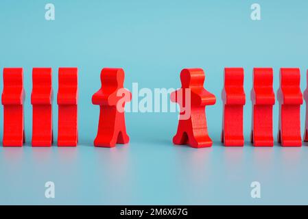 Two groups of wooden figures are standing in front of each other Stock Photo