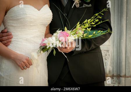 Groom and Bride after marriage with bride holding wedding bouquet flowers Stock Photo