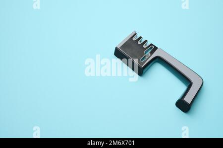 Manual sharpener for kitchen knives on a blue background Stock Photo