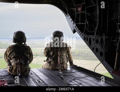 U.S. Army Soldiers assigned to 2nd Battalion, 3rd Combat Aviation Brigade, ride in a CH-47 Chinook helicopter at, Muscatatuck Urban Training Center, Ind., May 8, 2022. The helicopter transports individuals to safe locations as part of Guardian Response 22 to test unit readiness. (Photo by U.S. Army Spc. Caroline Sauder) Stock Photo