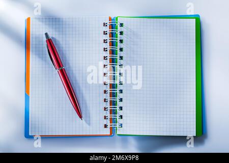 Checked notepad pen on white background. Stock Photo