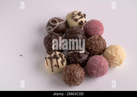 photo chocolates of different colors on a white background Stock Photo