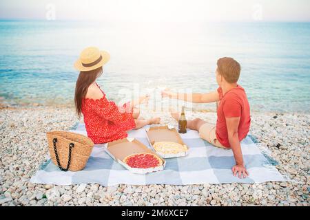 Lovely young couple having a picnic at the beach Stock Photo