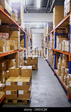 Stacked and ready to be delivered. Large warehouse storage shelves with boxes packed on them. Stock Photo