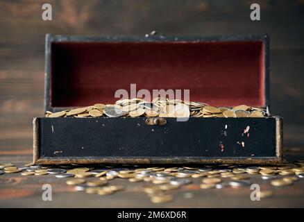 Open treasure chest filled with pile of coins. Stock Photo