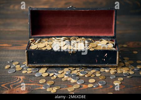 Open treasure chest filled with pile of coins. Stock Photo