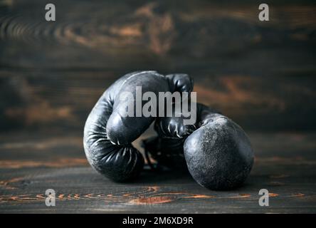 Old boxing gloves on wooden background Stock Photo