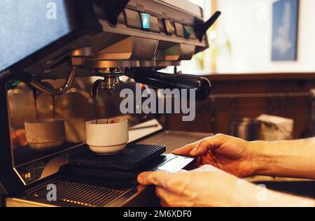Close up of espresso pouring from coffee machine Stock Photo