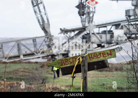KEPT DISTANCE sign, in the background a bucket wheel excavator, general, feature, marginal motif, symbolic photo The village of Luetzerath on the west side of the Garzweiler opencast lignite mine will be cleared and dredged in January 2023, Luetzerath, 05.01.2023, Stock Photo