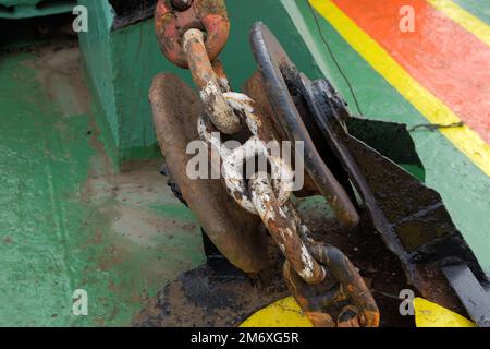 Anchor chain from the anchor winch on the foredeck. dirty and rusty chain Maritime background Stock Photo