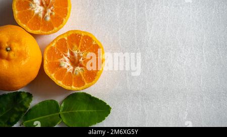 Orange with cut in half and green leaves isolated on white background Stock Photo
