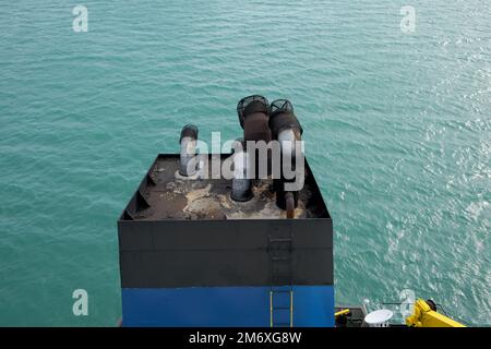 View from above the chimney of an anchored cargo ship. Stock Photo
