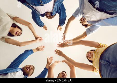 Satisfied group of cheerful friends cheering, celebrating good result and goal achievement. Stock Photo