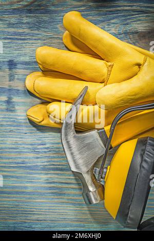 Composition of safety workwear claw hammer on wooden board construction concept. Stock Photo