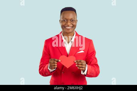 Happy handsome young African American man in red suit holding Valentine and smiling Stock Photo