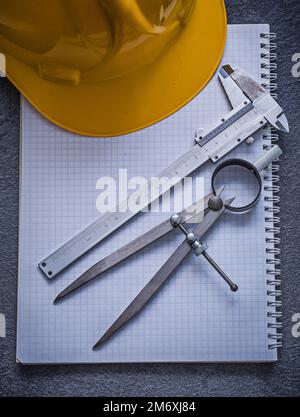 Copybook building helmet pair of compasses slide caliper construction concept. Stock Photo