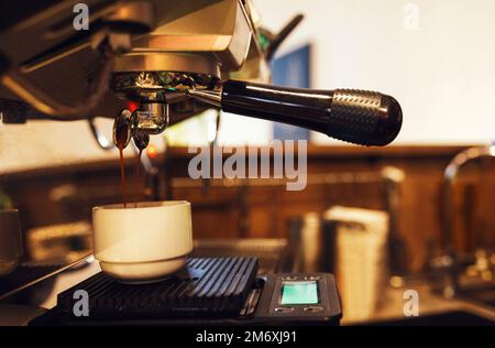 Close up of espresso pouring from coffee machine Stock Photo