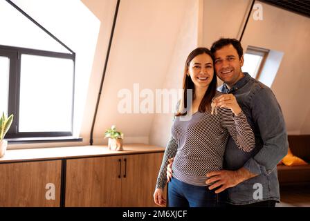 Appy Young Couple Holding Showing Key Standing In New Flat Stock Photo