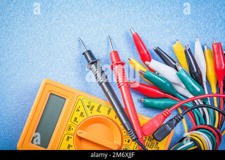 Crocodile cables composition digital multimeter on blue background electricity concept. Stock Photo