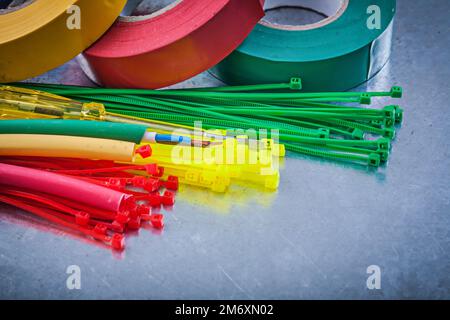 Insulating tapes plastic cable ties electric wires on metallic background. Stock Photo