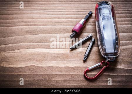 Interchangeable metal screwdriver heads in container on wood board copyspace. Stock Photo