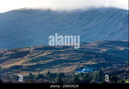 Isolated hill farmhouse burning turf for the fire, County Donegal, Ireland Stock Photo